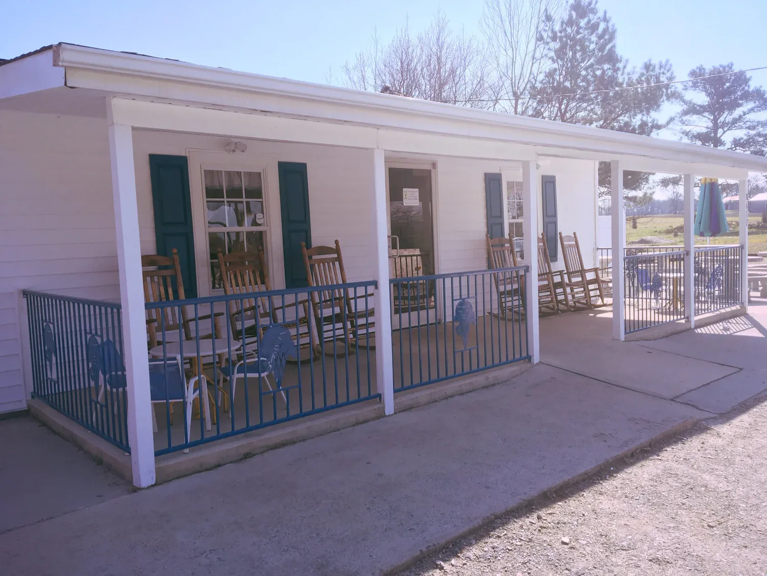 The white front porch at Sunni Sky's with wooden rocking chairs and blue railings cut with ice cream cone shapes